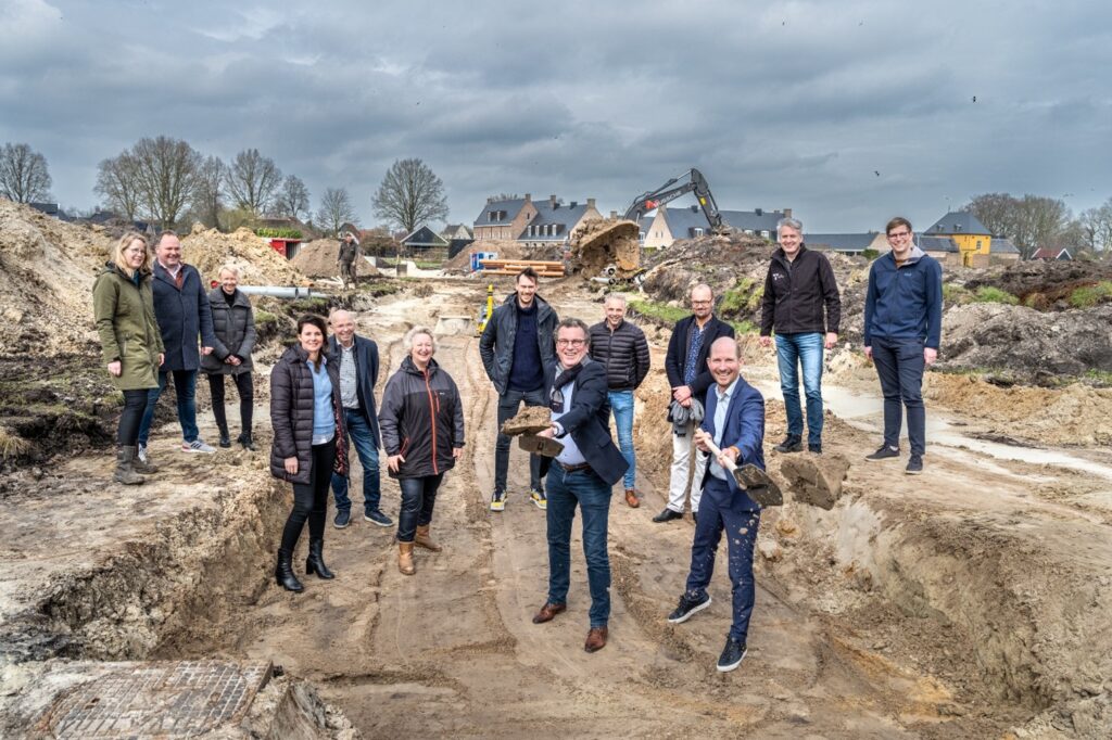 Wethouder Hans Haze (op de voorgrond links) en Helmich Heutink (op de voorgrond rechts) zetten onder toeziend oog van het projectteam vanuit de gemeente Westerkwartier en Heutink Groep de eerste schep in de grond van project De Besloten Wal